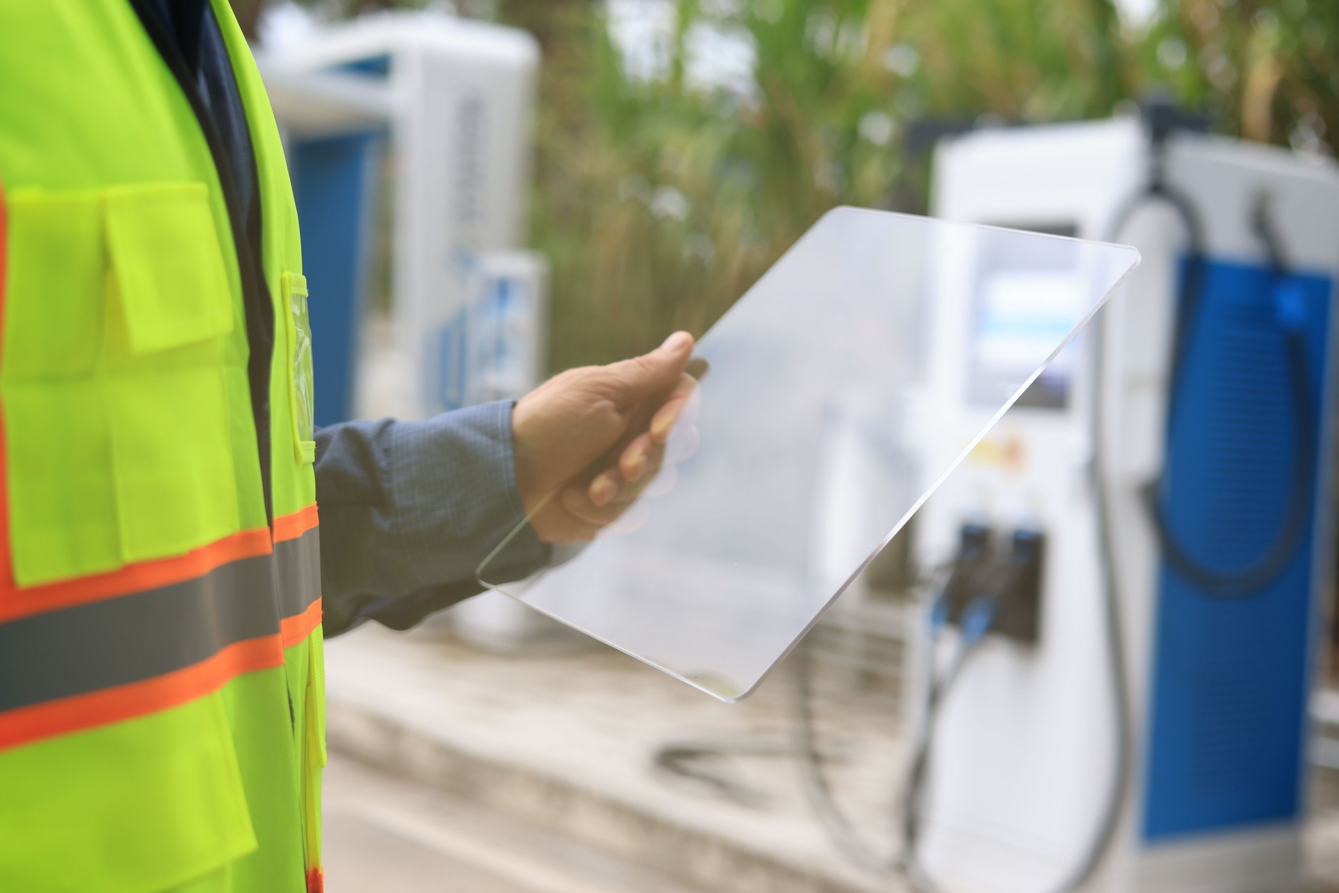 Two male engineers are checking the electric car power station. The energy engineer inspects and services the EV charger for electric vehicles.