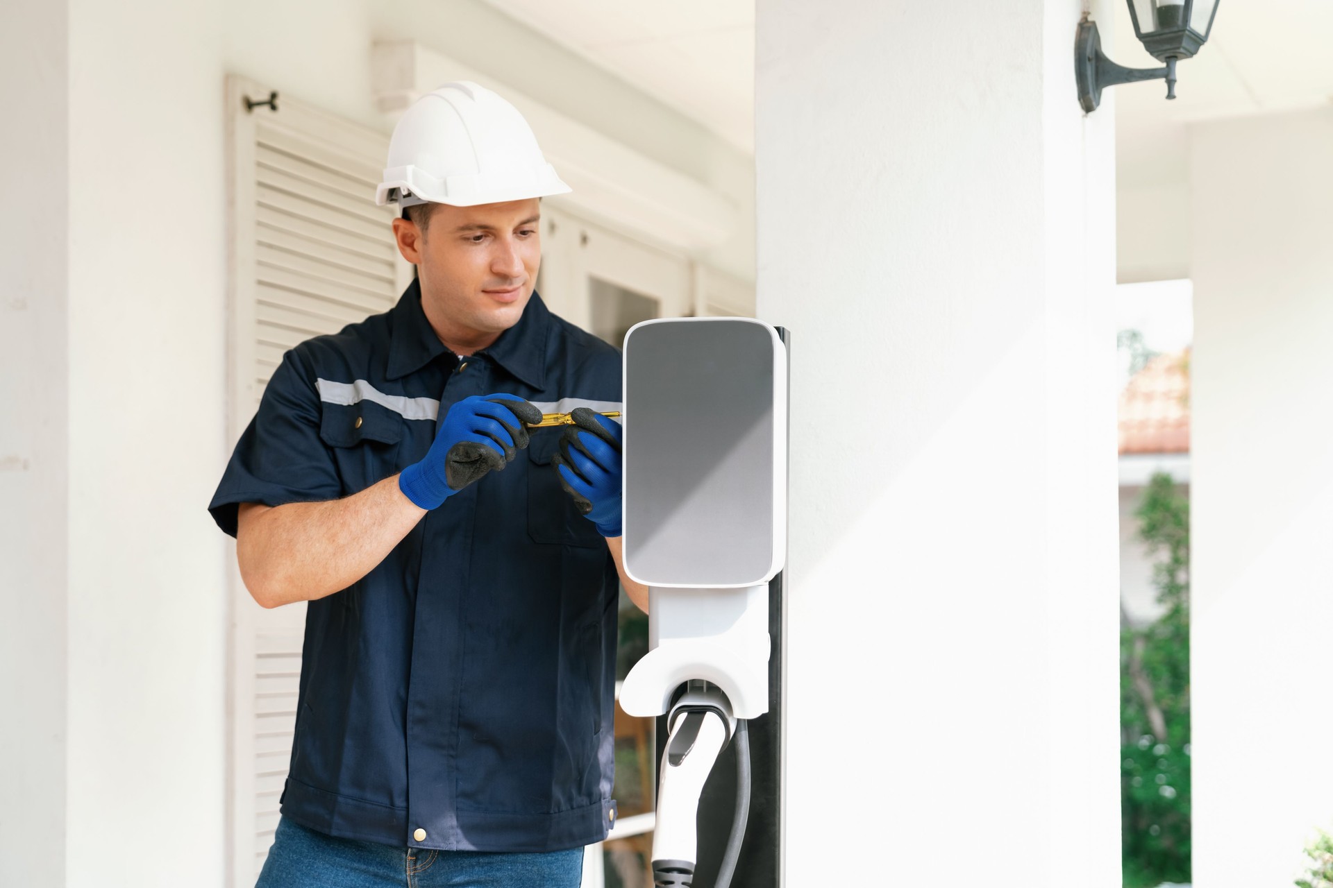 Qualified technician install home EV charging station. Synchronos