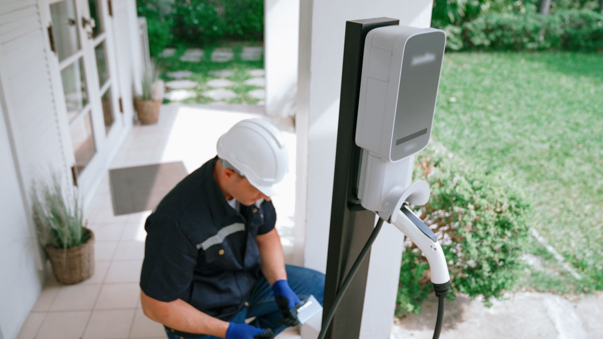 Qualified technician install home EV charging station. Synchronos